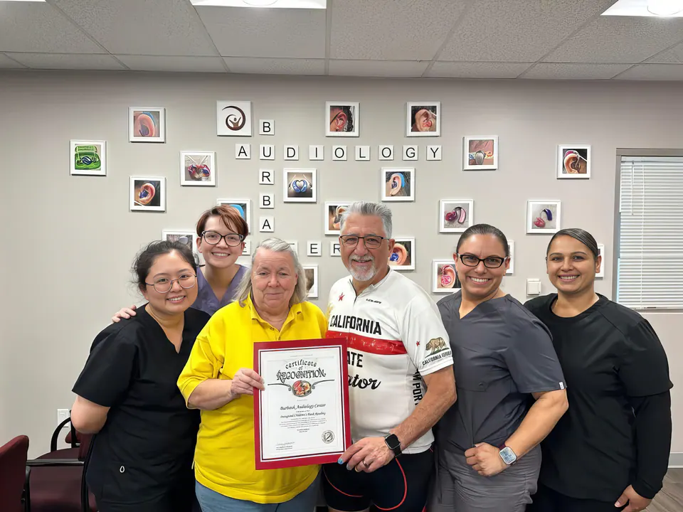 Dr. Frintner and members of the team holding a Certificate of Recognition presented to the practice